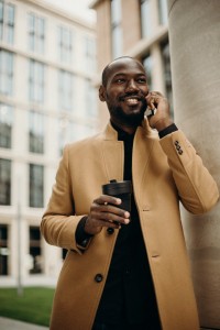 man-wearing-brown-jacket-using-smartphone-while-using-smartphone