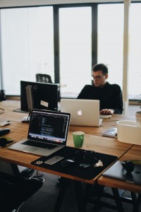 man-sits-behind-computers